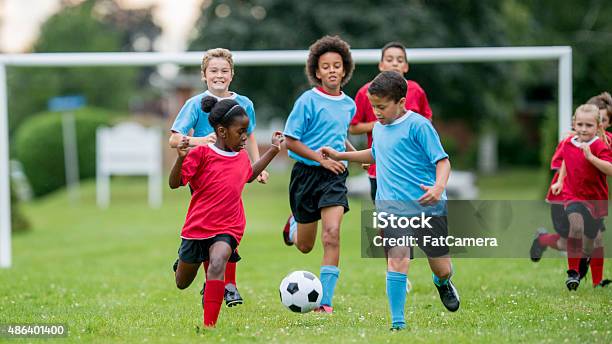 Children Chasing Soccer Ball During A Match Stock Photo - Download Image Now - Child, Soccer, Adolescence