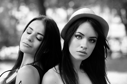 Two young beautiful girls sitting in the park