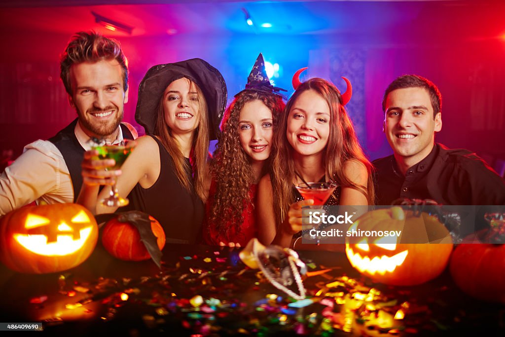 Toasting dreadful Halloween Young people cheering at Halloween Halloween Stock Photo