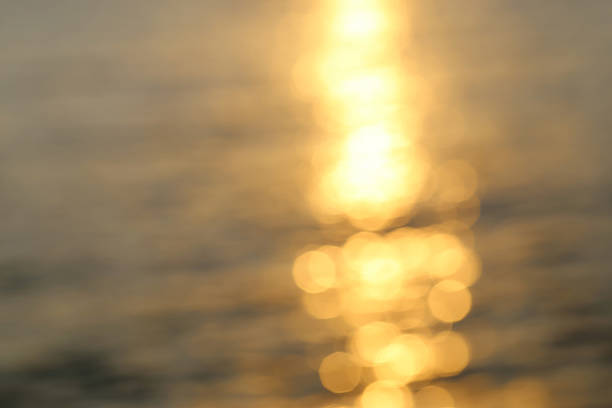 istock Abstract golden sunlight bokeh on blue sea water background. 486409834