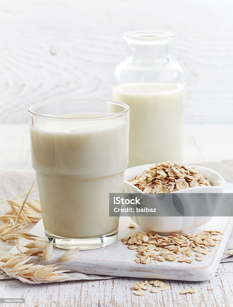 Oat milk Glass of oat milk on white wooden background Oats - Food Stock Photo