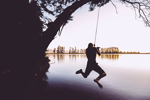 Teenager jumping into the lake