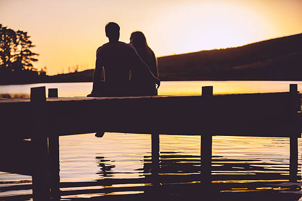 Loving couple on a jetty in sunset