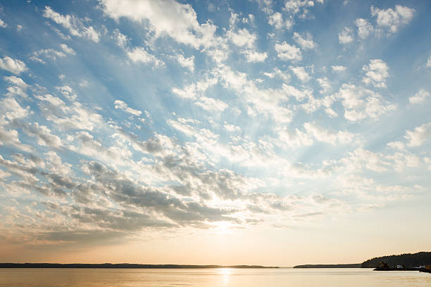 Clouds and sun rays over lake at sunrise