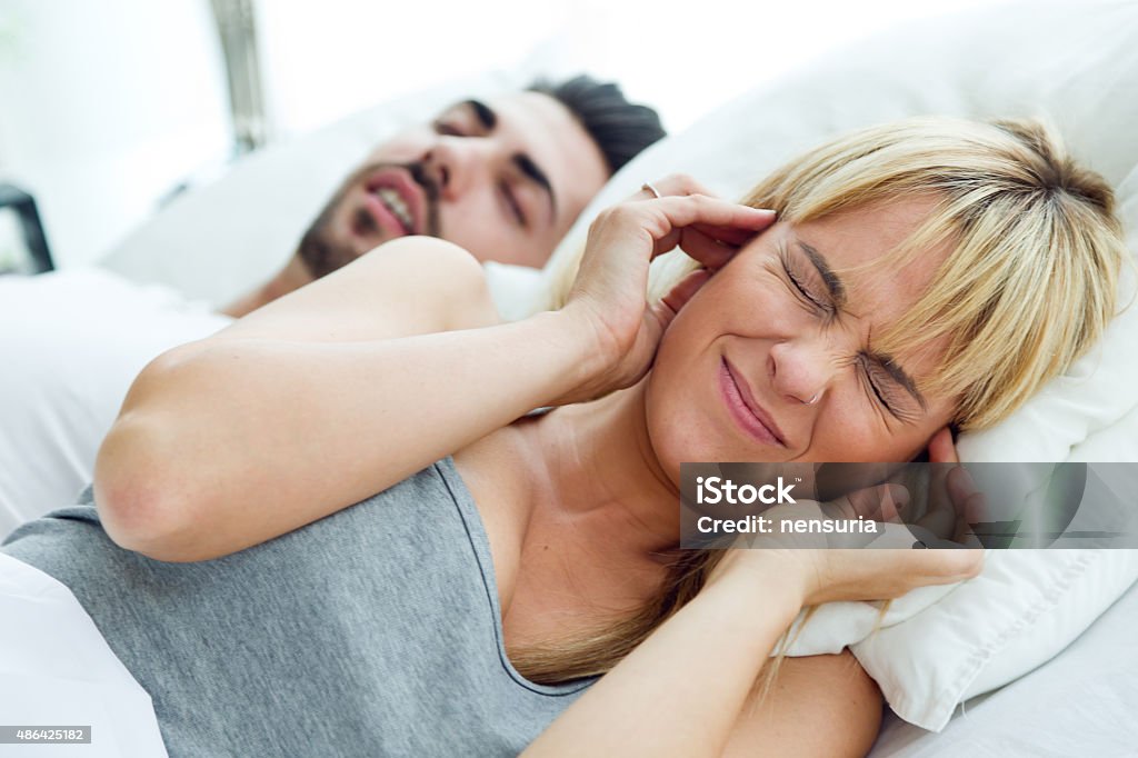 Young woman who can not sleep because her husband snores. Portrait of woman who can not sleep because her husband snores. Snoring Stock Photo