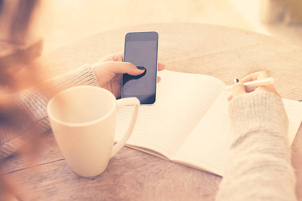 istock girl with cell phone and diary, vintage photo effect 486425548