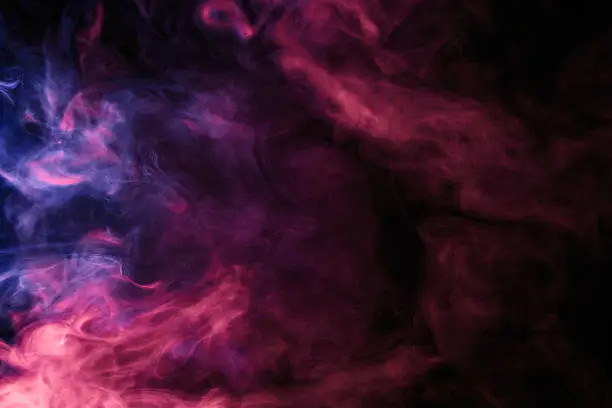 Photo of Abstract colored smoke hookah on a black background.