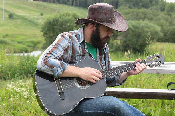 istock guitarist in a cowboy hat on the nature 486430286