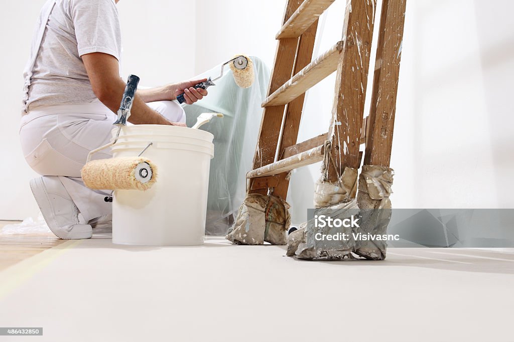 Homem pintor no trabalho com uma montanha, balde e escada - Foto de stock de Pintor royalty-free