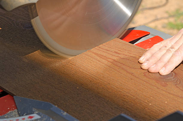 Wood siding contractor using a miter saw Wood siding contractor using a electric compound miter saw to cut window and door trim boards on the construction of a new home miter saw stock pictures, royalty-free photos & images