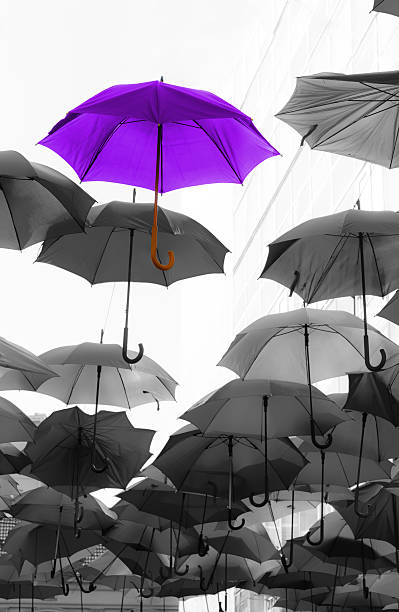 umbrella standing out from the crowd unique concept stock photo