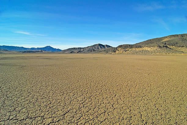 Dry Desert Lakebed Cracked earth in desert salt flats near Baker, California. lakebed stock pictures, royalty-free photos & images