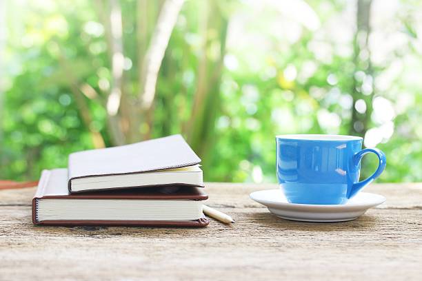 istock Notebook  and coffee cup on wooden table 486438060