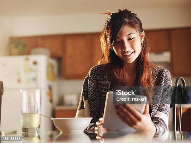 Asiatische Teen Mädchen Mit Tablet Beim Frühstück Stockfoto und mehr Bilder von Asiatischer und Indischer Abstammung - Asiatischer und Indischer Abstammung, Frauen, Küche