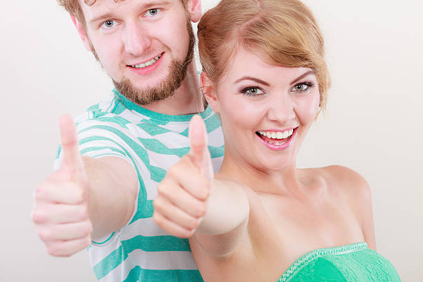 istock happy couple excited smiling holding thumb up gesture, 486439068