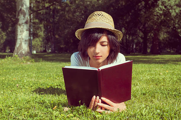 istock Woman reads a book on the meadow 486439435