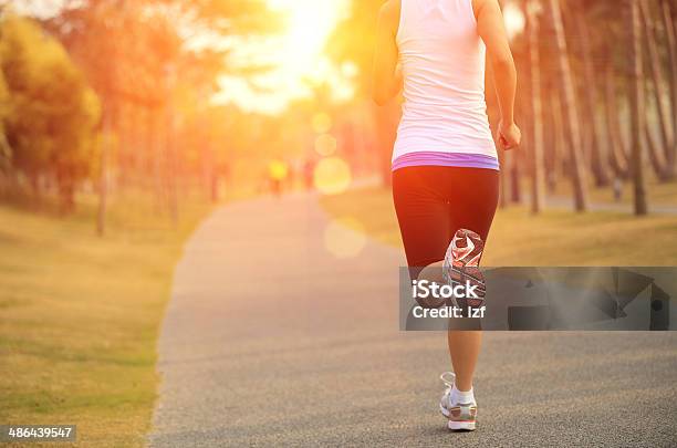 Cropped Image Of Jogging Woman Sun In Background Stock Photo - Download Image Now - Activity, Adult, Adults Only