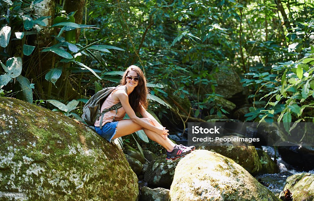 Ready for adventure? Shot of a beautiful young woman sitting on a rock by a stream in the foresthttp://195.154.178.81/DATA/i_collage/pi/shoots/783166.jpg 20-29 Years Stock Photo