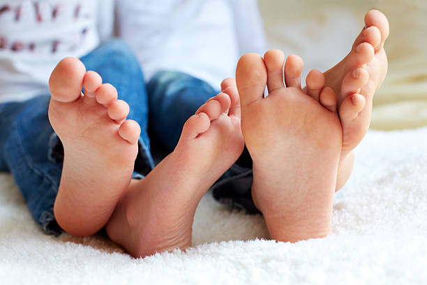 lustige kinder foots ist barfuß, nahaufnahme. - child human foot barefoot jeans stock-fotos und bilder