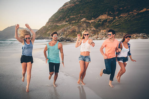 istock Friends running along the beach 486443313