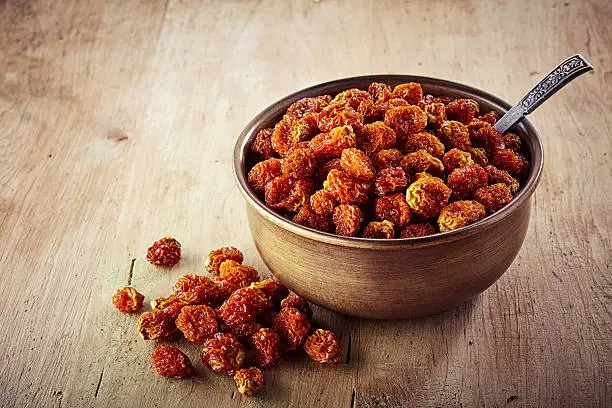 Bowl of dried cape gooseberries (physalis peruviana) on wooden background