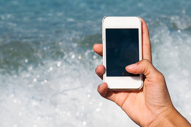 istock Woman using mobile phone by the beach 486444847