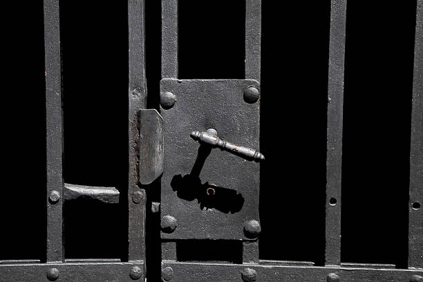 Old rusty metal lock with bars Closeup on old rusty metal bar door with old-fashioned lock dungeon medieval prison prison cell stock pictures, royalty-free photos & images