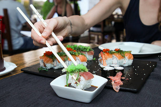 istock dipping tuna sushi into soya sauce 486450046