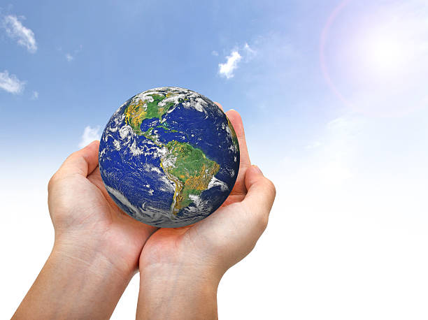 istock Earth planet in female hand and blue sky 486450306