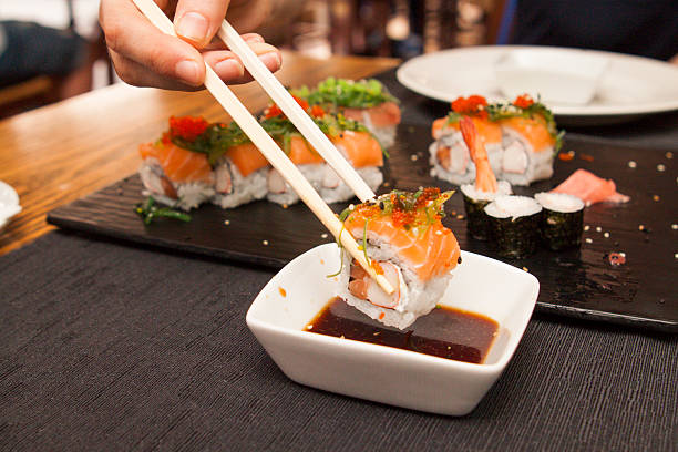 istock dipping salmon sushi into soya sauce 486450340