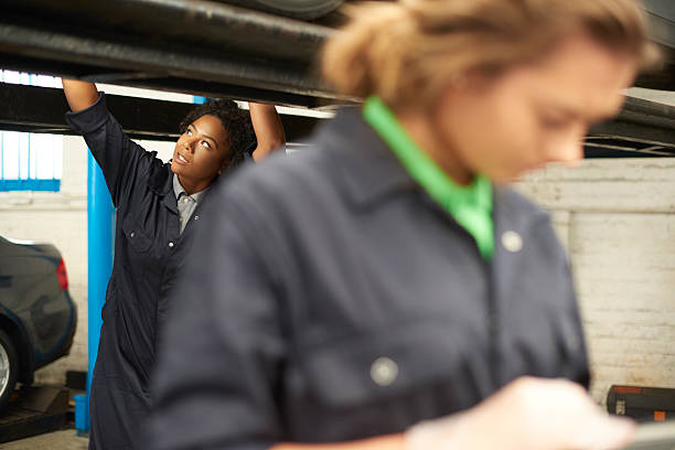 istock female car mechanics servicing car. 486451264