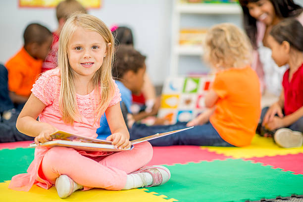 istock Cute Little Girl Looking at Picture Book 486455114