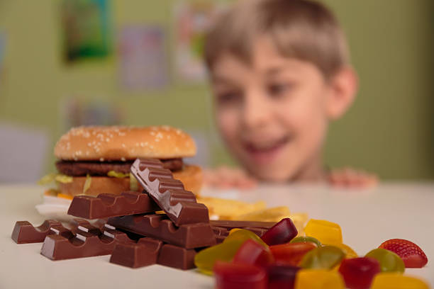 chłopiec cieszy się jego niezdrowe lunch - overweight child eating hamburger zdjęcia i obrazy z banku zdjęć