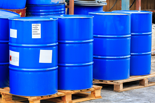 Big blue barrels standing on wooden pallets on a chemical plant