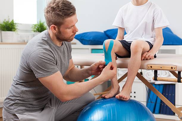 istock Physical therapist applying medical tape 486463646