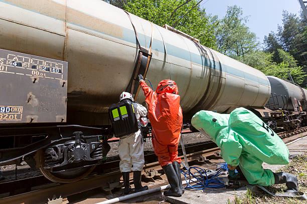 Toxic chemicals acids emergency team train crash A team working with toxic acids and chemicals is securing a chemical cargo train tanks crashed near Sofia, Bulgaria. Teams from Fire department are participating in an emergency training with spilled toxic and flammable materials. biochemical weapon photos stock pictures, royalty-free photos & images