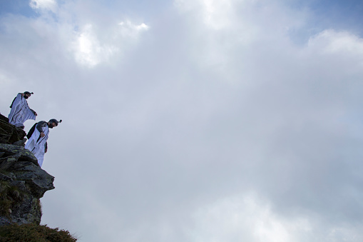 Two wingsuit jumpers about to launch, mountain summit