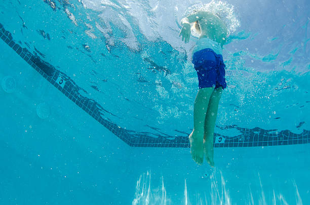 istock Boy swimming up towards the surface shot underwater 486466216