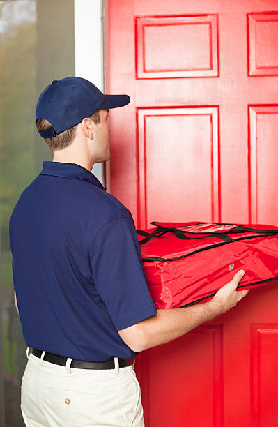istock Pizza Delivery Man Delivering Take-out Package to Customer's Door 486468254