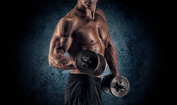 istock Muscular man with dumbbells on black background 486468678