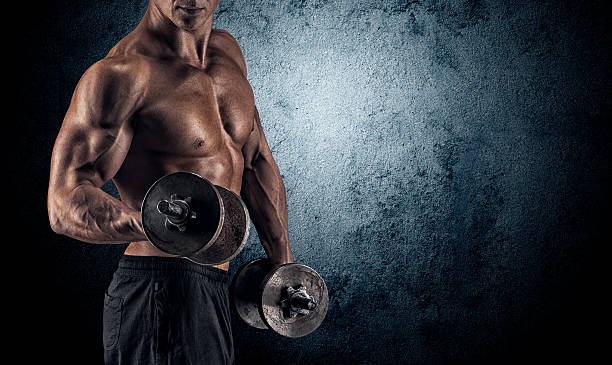 istock Muscular man with dumbbells on black background 486468684