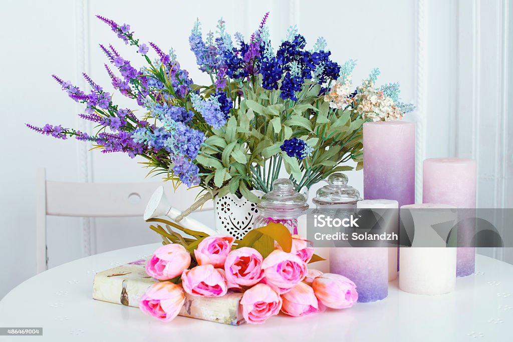 Still life of lavender flower tulips, candles and a book Still life of lavender flower tulips, candles and a book on light background 2015 Stock Photo