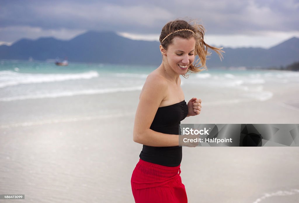 Woman jumping at the beach. Beautiful young woman is enjoying free time at the beautiful sandy beach Active Lifestyle Stock Photo