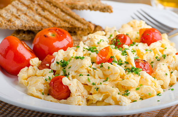 istock Scrambled eggs with baked tomatoes and chives 486480118