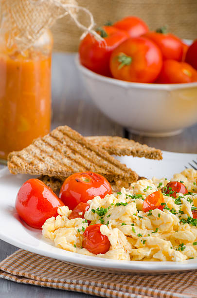 istock Scrambled eggs with baked tomatoes and chives 486480122