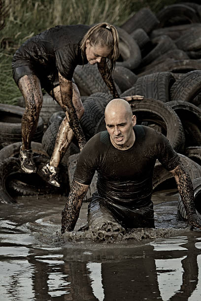 istock couple crossing muddy canal with tyres 486480398