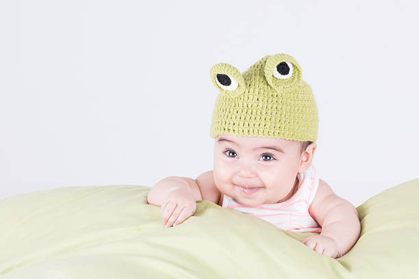 istock Little baby with frog hat smiling and looking up 486484624