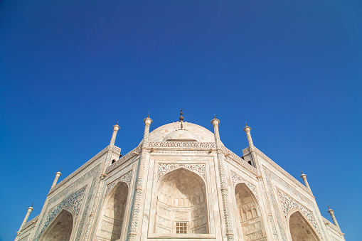 Close up detailed view of South side of Taj Mahal on blue sky.