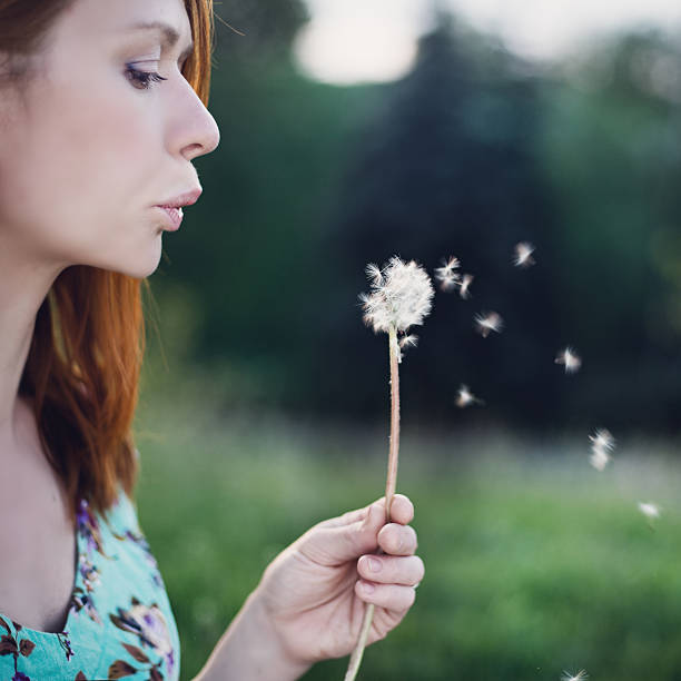 istock Girl blowing dandelion 486490060