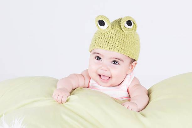 istock Cheerful toddler posing with knitting frog beret on soft pillow 486490362